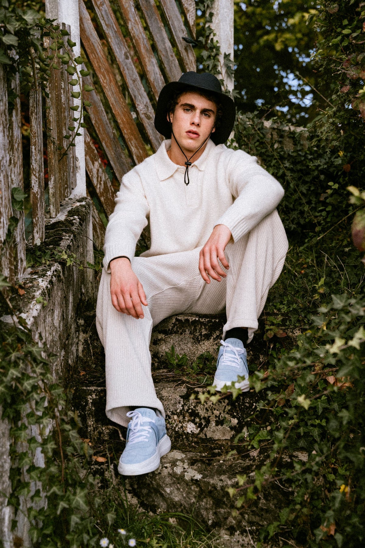 EVI G025 Bleu Azur – blue suede sneaker worn by a man, outdoor stone staircase setting, Made in France